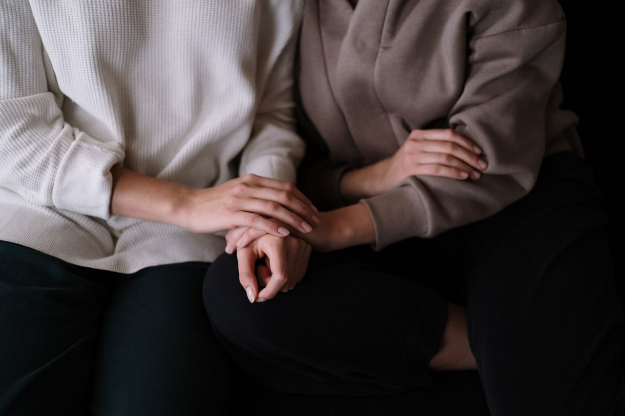 about-us Two individuals sitting together, providing comfort and support with gentle touch.